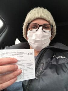 Dr. Winner holding up her first COVID-19 vaccine form